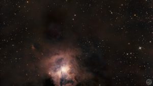Fotografia astronómica profunda exibindo a Nebulosa da Íris (NGC 7023) no centro, caracterizada por um núcleo estelar brilhante intensamente rodeado por delicadas e complexas nuvens de poeira reflectora de tons azuis e anil. Todo o campo em torno da nebulosa revela extensas e imponentes massas de poeira escura e acastanhada que bloqueiam a luz de fundo. A imagem encontra-se ponteada por estrelas nítidas de diversas colorações sobre um céu negro e profundo.